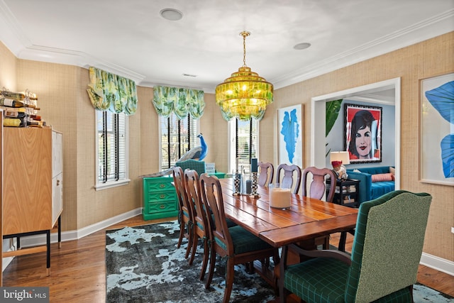 dining space with baseboards, wood finished floors, ornamental molding, wallpapered walls, and a chandelier