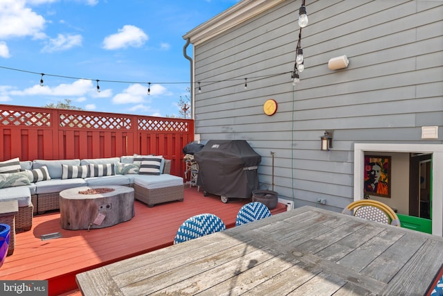 deck featuring area for grilling, an outdoor living space with a fire pit, outdoor dining area, and fence