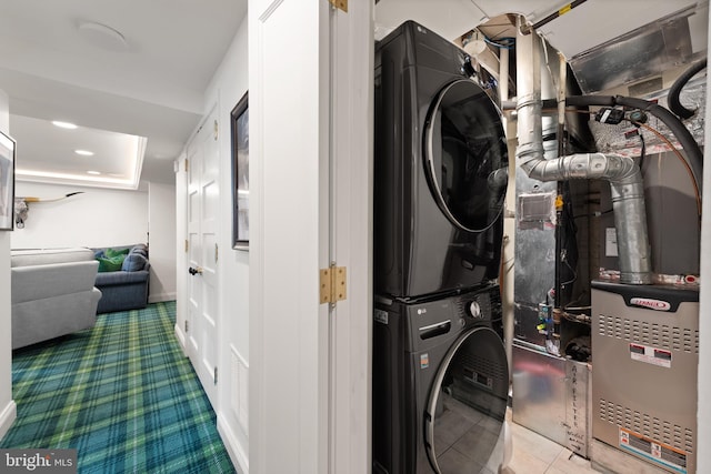 laundry room featuring stacked washer / dryer and carpet flooring