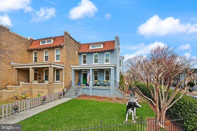 view of front facade featuring mansard roof, a porch, a tile roof, and brick siding