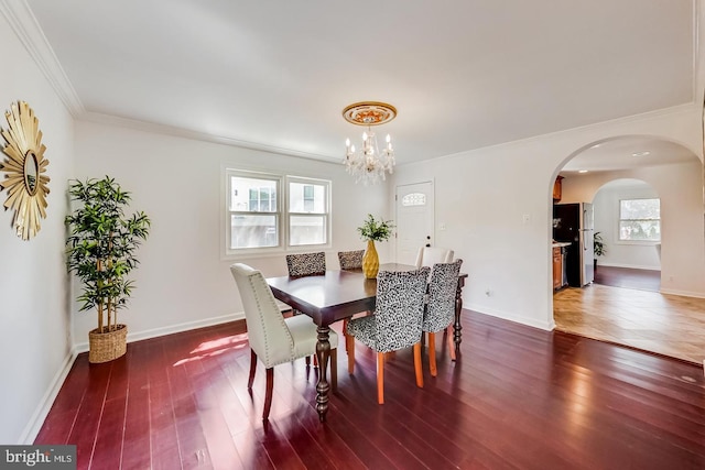 dining space with a chandelier, arched walkways, crown molding, and dark wood finished floors
