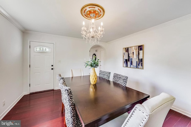 dining space with baseboards, arched walkways, a notable chandelier, crown molding, and dark wood-type flooring