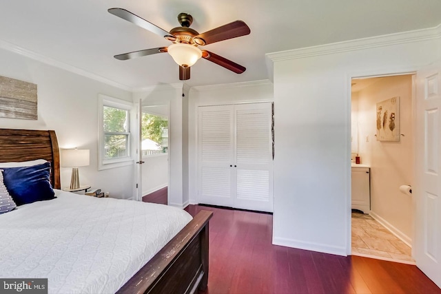 bedroom featuring dark wood-style flooring, ornamental molding, baseboards, and a closet
