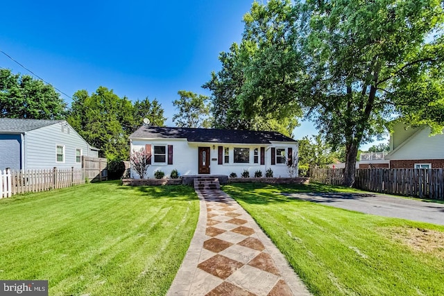 bungalow-style home with a front yard and fence