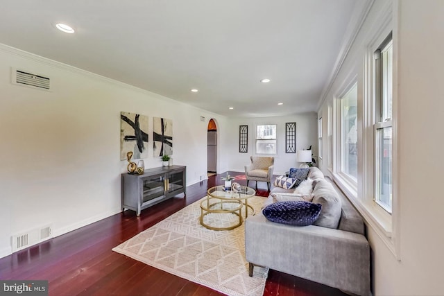living area featuring arched walkways, dark wood-style floors, visible vents, and recessed lighting
