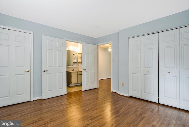 unfurnished bedroom with baseboards, a closet, and wood finished floors