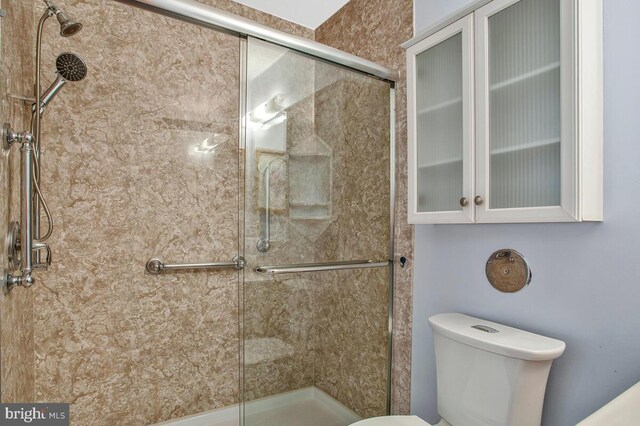 full bath featuring toilet and a stall shower