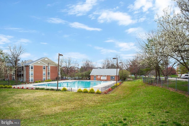 community pool featuring an outbuilding, fence, and a lawn