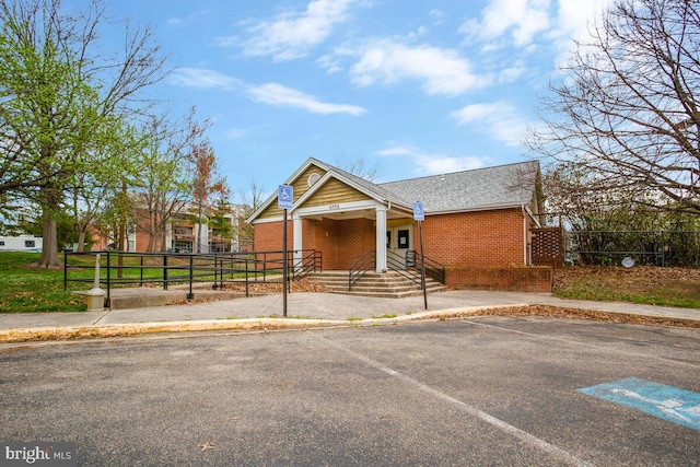 view of front facade with fence and brick siding