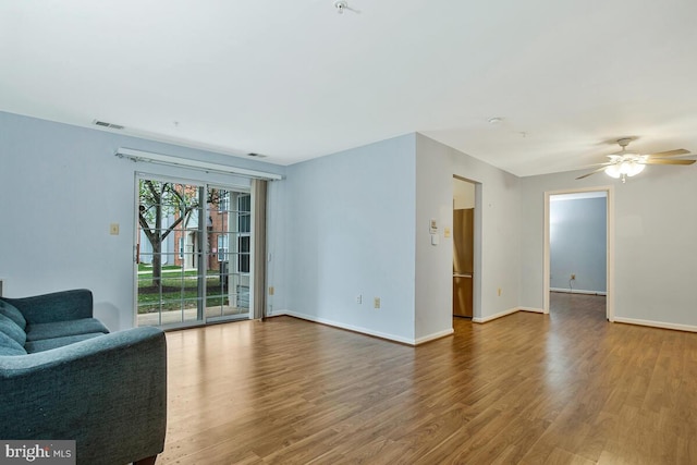 unfurnished living room featuring baseboards, visible vents, wood finished floors, and a ceiling fan