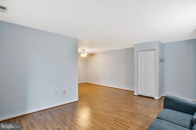 unfurnished living room with baseboards, visible vents, wood finished floors, and ceiling fan