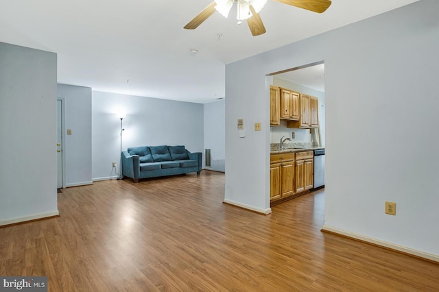 living room featuring baseboards, light wood-style flooring, and a ceiling fan