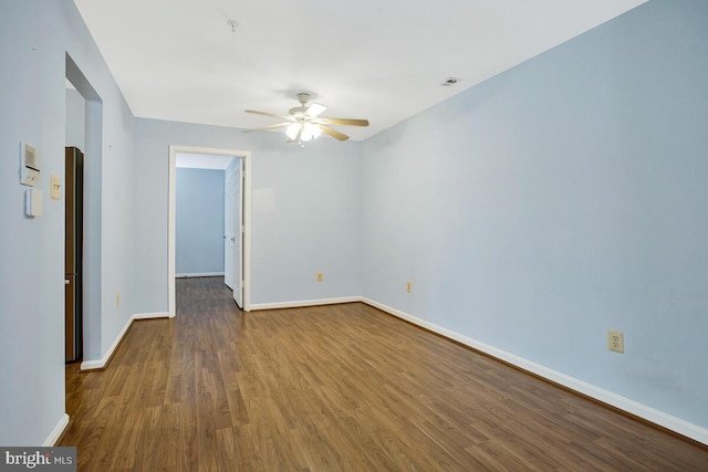 empty room with wood finished floors, visible vents, baseboards, and ceiling fan