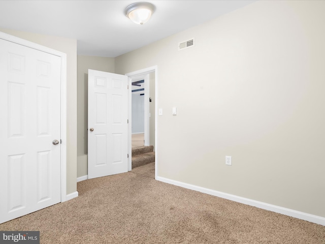 unfurnished bedroom featuring carpet, visible vents, and baseboards