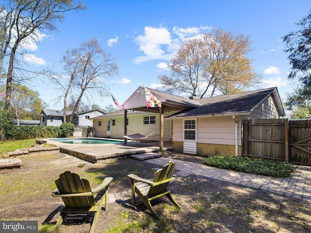 back of property featuring a patio area, a fenced in pool, and fence