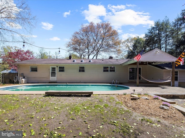 back of property featuring a patio area, fence, and an outdoor pool