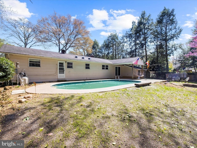 rear view of property with a fenced in pool, a yard, a patio area, and fence
