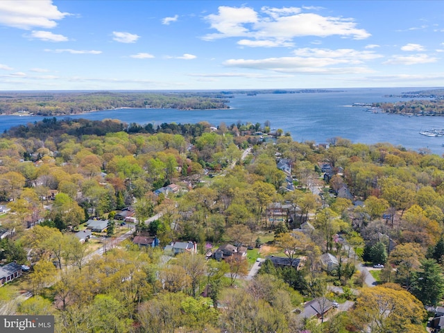 birds eye view of property featuring a water view and a wooded view