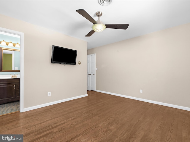 interior space featuring ceiling fan, visible vents, wood finished floors, a sink, and baseboards