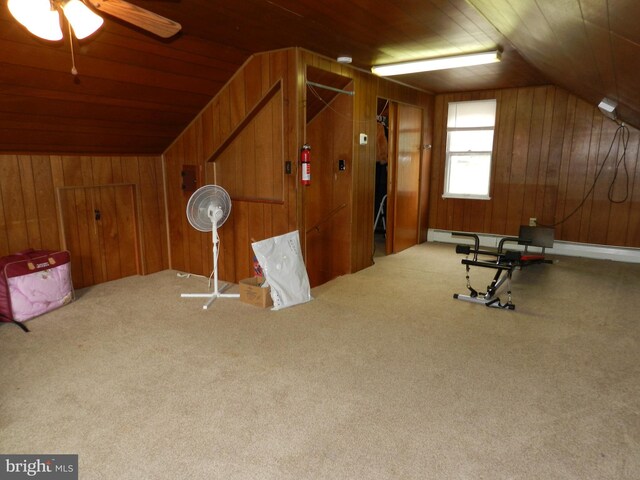 bonus room with wood walls, vaulted ceiling, wooden ceiling, a baseboard radiator, and a ceiling fan