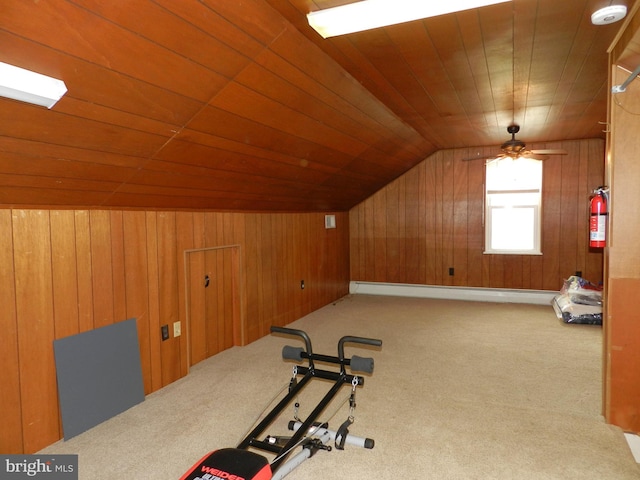 exercise area featuring baseboard heating, wooden walls, wooden ceiling, and lofted ceiling