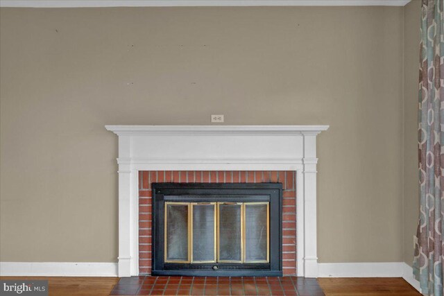 details featuring a fireplace, baseboards, and wood finished floors