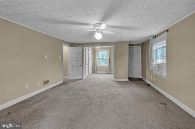 unfurnished room featuring a healthy amount of sunlight, ceiling fan, baseboards, and carpet flooring