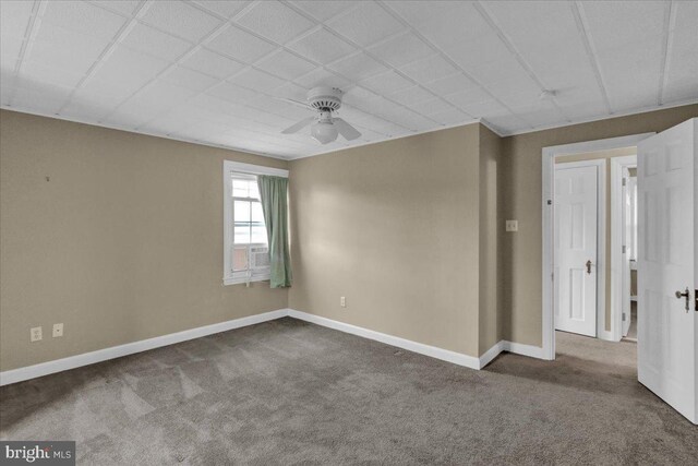 unfurnished room featuring carpet flooring, baseboards, and a ceiling fan