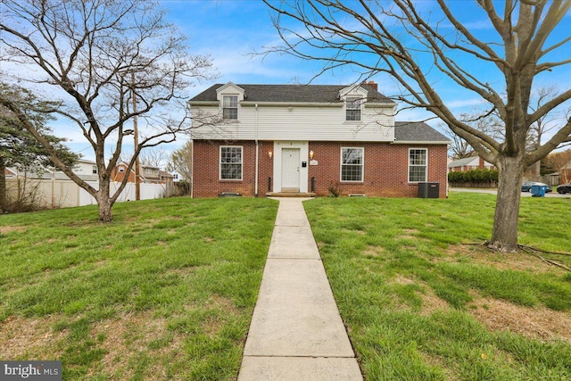 view of front of home featuring a chimney, fence, cooling unit, brick siding, and a front lawn