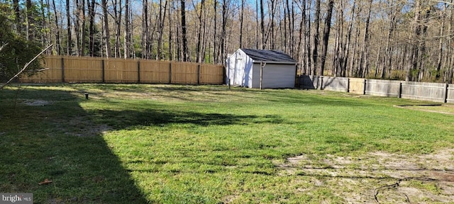 view of yard with an outbuilding, a storage unit, and a fenced backyard
