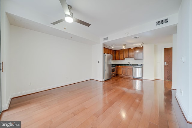 unfurnished living room featuring visible vents, ceiling fan, rail lighting, and light wood-style flooring