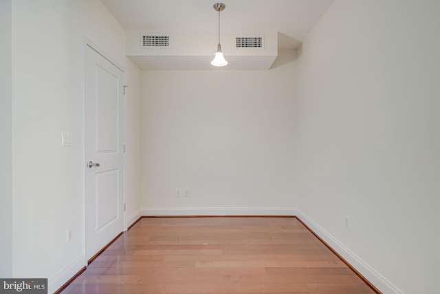 unfurnished dining area featuring visible vents, light wood-style flooring, and baseboards