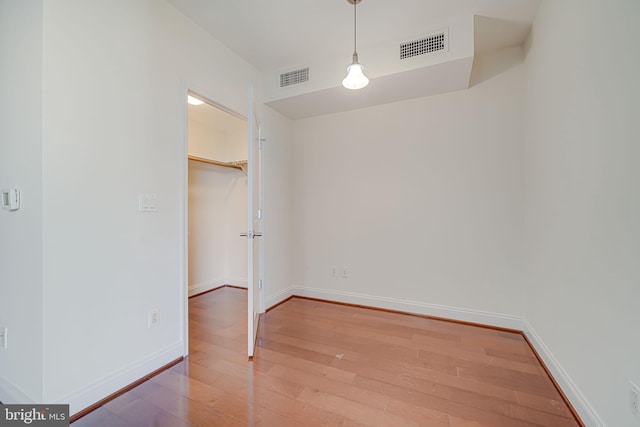unfurnished dining area featuring visible vents, hardwood / wood-style flooring, and baseboards