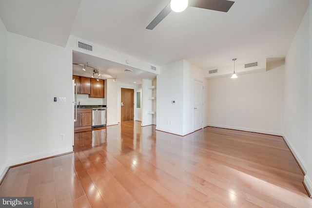 unfurnished living room featuring visible vents, light wood-type flooring, a ceiling fan, and baseboards
