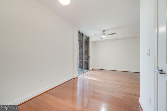 unfurnished room featuring baseboards, wood finished floors, and ceiling fan