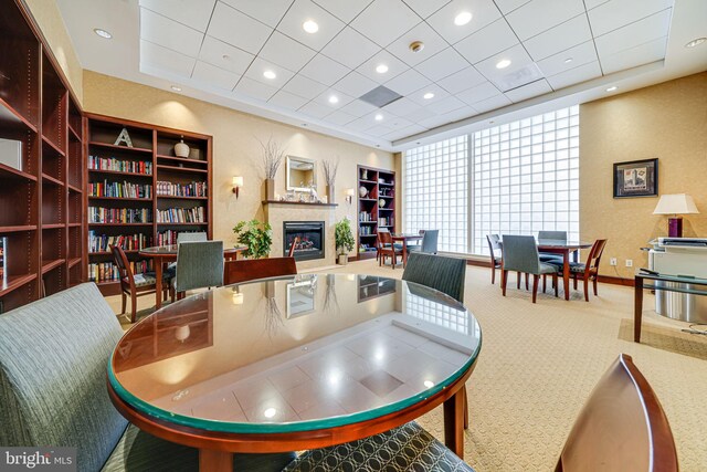 carpeted dining space featuring a glass covered fireplace, recessed lighting, and built in features
