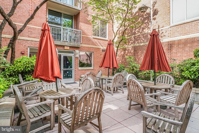 view of patio / terrace with a balcony and outdoor dining area