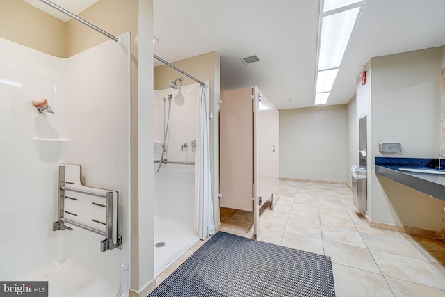 bathroom featuring tile patterned floors, visible vents, a shower stall, and vanity