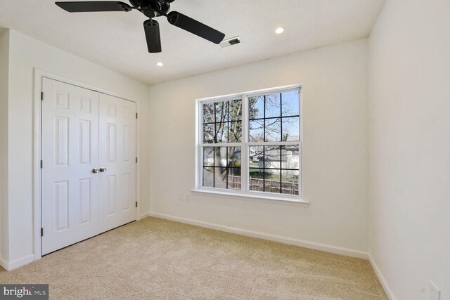 unfurnished bedroom featuring a closet, baseboards, recessed lighting, visible vents, and carpet