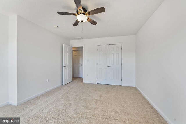 unfurnished bedroom featuring a closet, ceiling fan, baseboards, and carpet floors