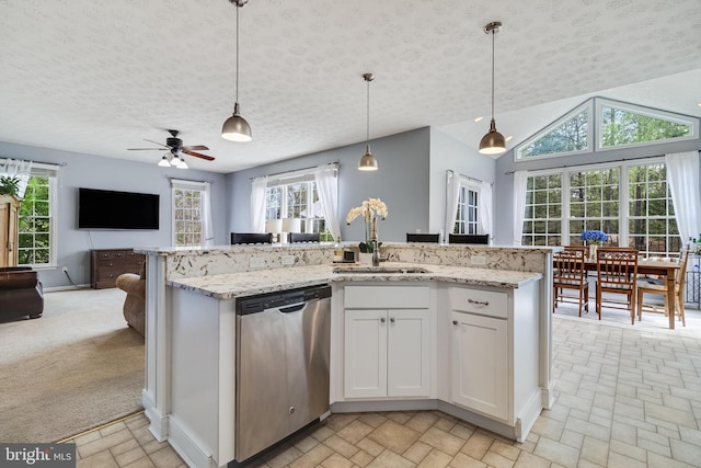 kitchen featuring open floor plan, dishwasher, a sink, and hanging light fixtures