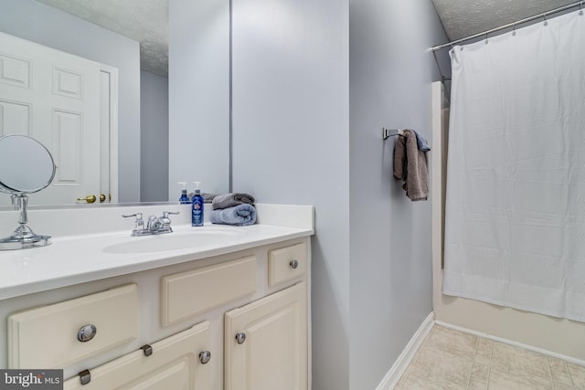 full bath featuring a textured ceiling, a shower with shower curtain, vanity, and baseboards