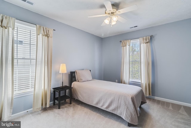 carpeted bedroom with ceiling fan, baseboards, and visible vents