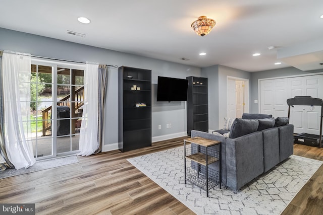 living room with visible vents, baseboards, recessed lighting, and wood finished floors