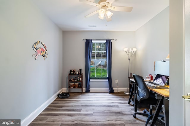 office space featuring wood finished floors, baseboards, a ceiling fan, and visible vents
