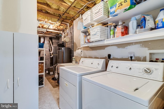 laundry room featuring water heater, independent washer and dryer, and laundry area