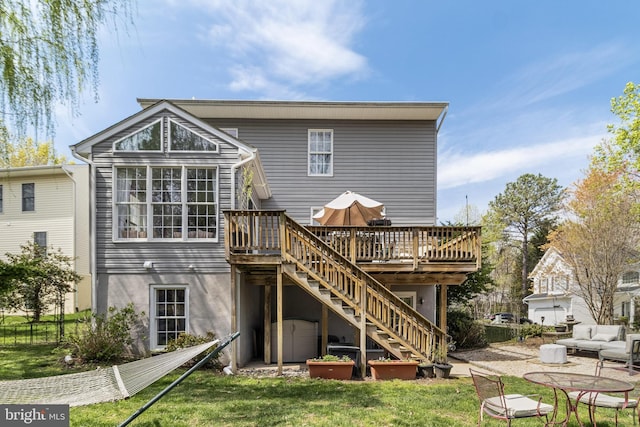 rear view of property featuring stairs, a patio, a wooden deck, and a lawn
