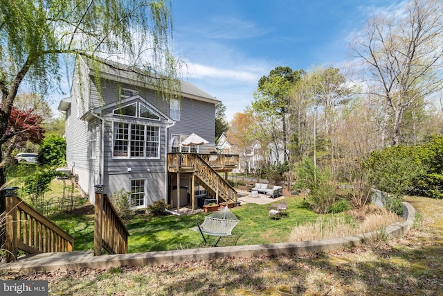 back of property featuring a wooden deck, a lawn, and stairs