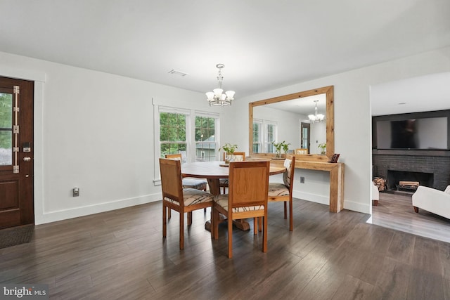 6750 Stonehurst Ct, Warrenton, VA 20187 - dining room with a chandelier, baseboards, dark wood-style flooring, and a brick fireplace