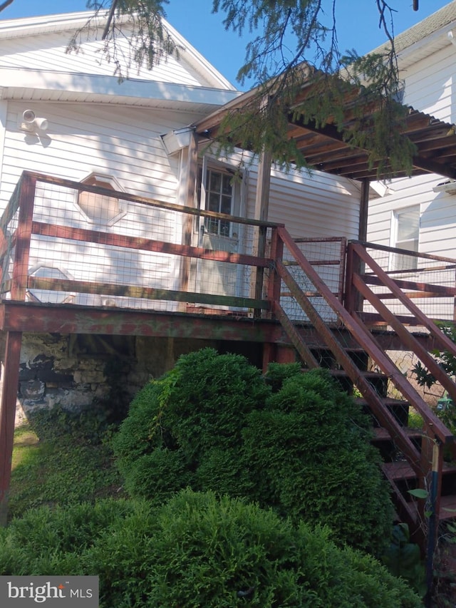view of property exterior with stone siding and stairs
